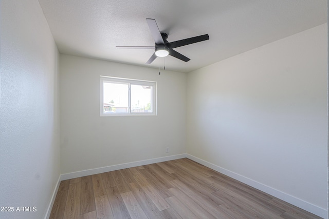 empty room with baseboards, a ceiling fan, and light wood-style flooring
