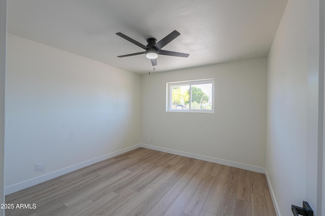 empty room featuring a ceiling fan, baseboards, and light wood finished floors