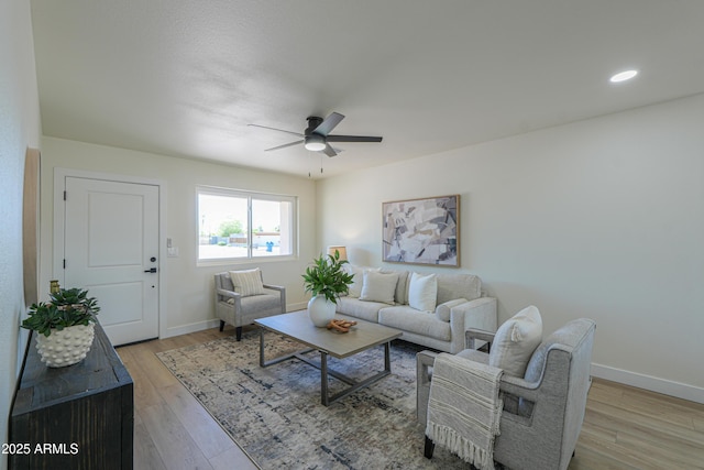 living area with baseboards, a ceiling fan, light wood-style floors, and recessed lighting