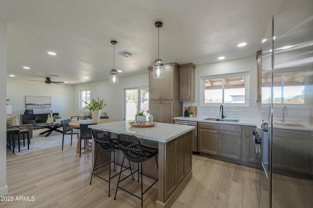 kitchen featuring a sink, stainless steel appliances, light wood-type flooring, and visible vents