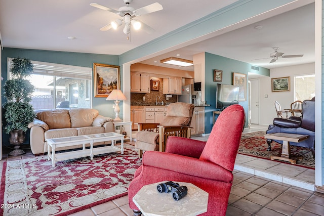 tiled living room with ceiling fan and sink