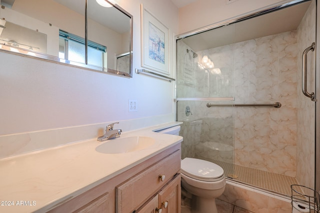 bathroom with tile patterned floors, vanity, toilet, and a shower with door