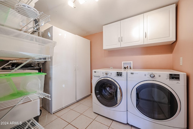 laundry area featuring cabinets, independent washer and dryer, and light tile patterned floors