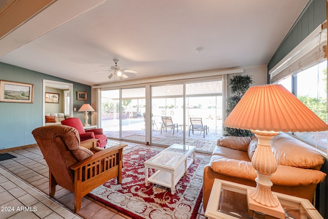 living room with plenty of natural light, ceiling fan, and vaulted ceiling