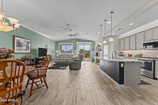 kitchen with a center island with sink, appliances with stainless steel finishes, hanging light fixtures, and gray cabinets