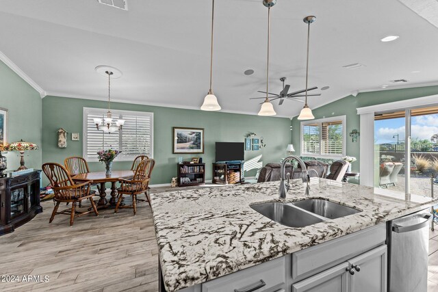 kitchen featuring a center island with sink, light wood-type flooring, plenty of natural light, and sink