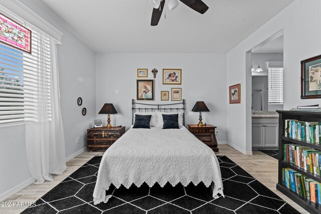 bedroom with ensuite bath, light hardwood / wood-style flooring, and ceiling fan