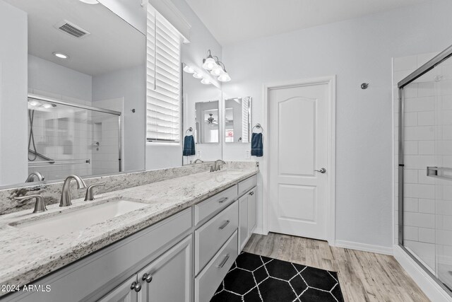 bathroom featuring a shower with door, hardwood / wood-style floors, and vanity