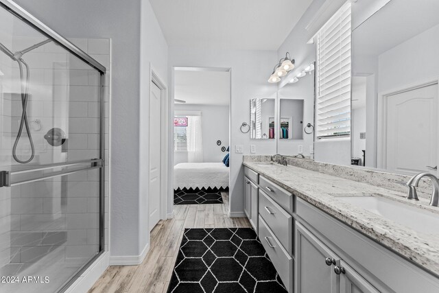 bathroom with vanity, a shower with door, and hardwood / wood-style flooring