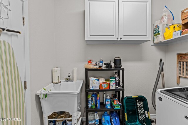 washroom with washer / clothes dryer and cabinets