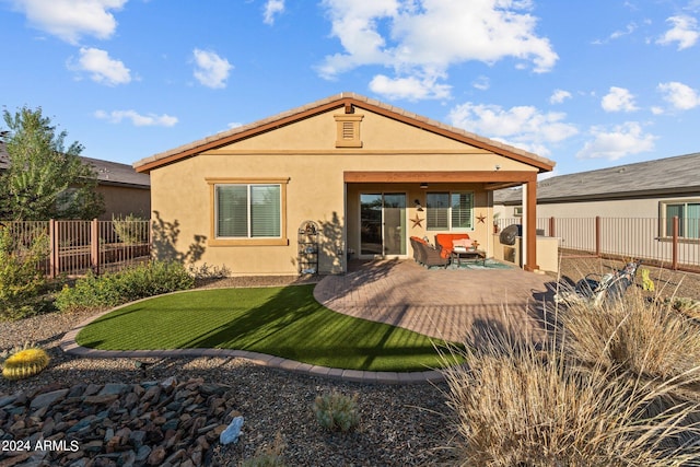 rear view of house featuring a patio and a yard