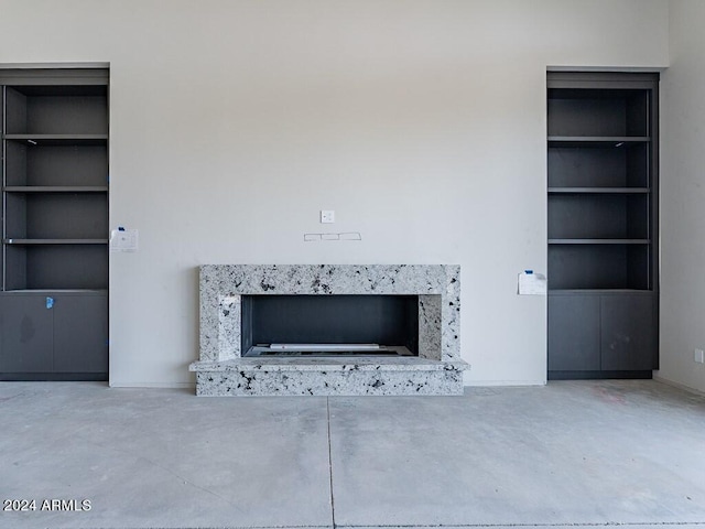 interior details featuring a fireplace, concrete floors, and built in features