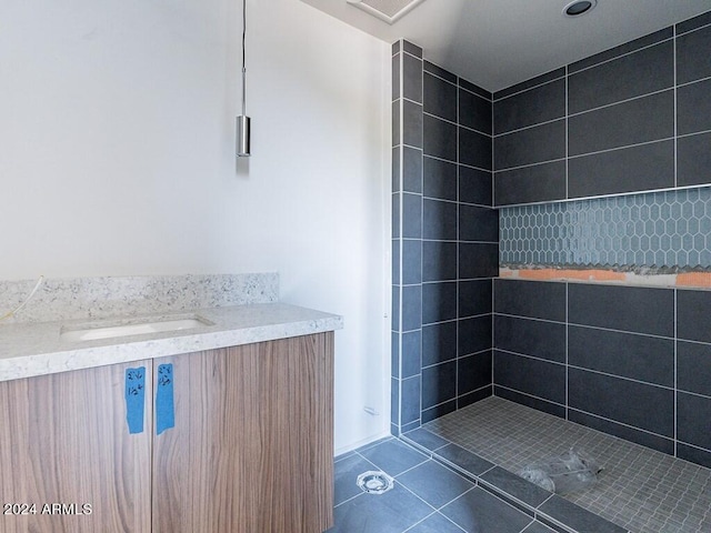 bathroom with a tile shower and tile patterned flooring