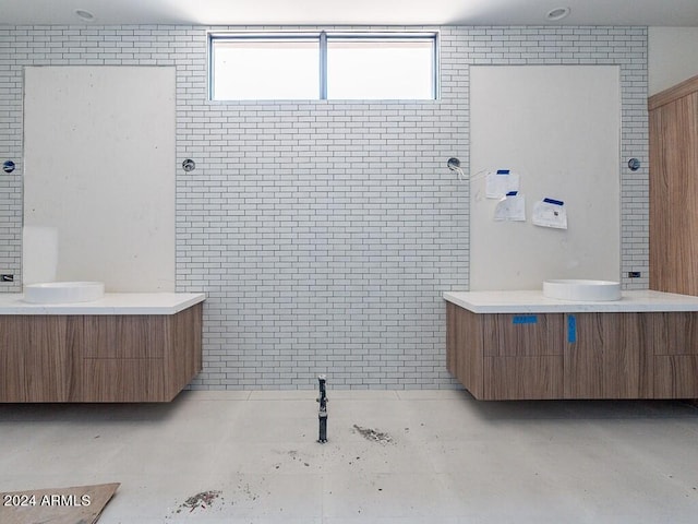 bathroom featuring vanity, tiled shower, and concrete floors