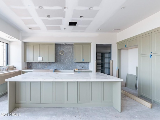 kitchen with tasteful backsplash, light stone counters, coffered ceiling, beam ceiling, and gray cabinets