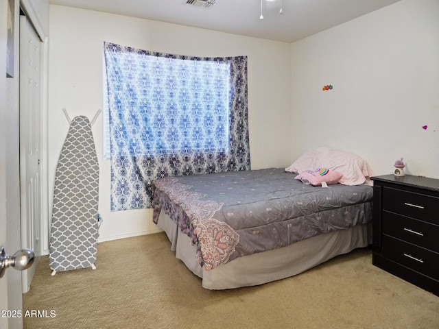 bedroom with visible vents, a closet, and carpet flooring