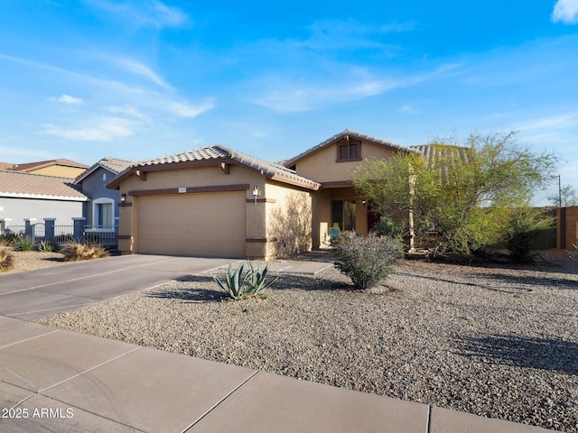 mediterranean / spanish-style house featuring stucco siding, an attached garage, concrete driveway, and fence