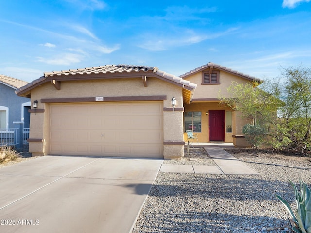 view of front of house with a tiled roof, stucco siding, an attached garage, and concrete driveway