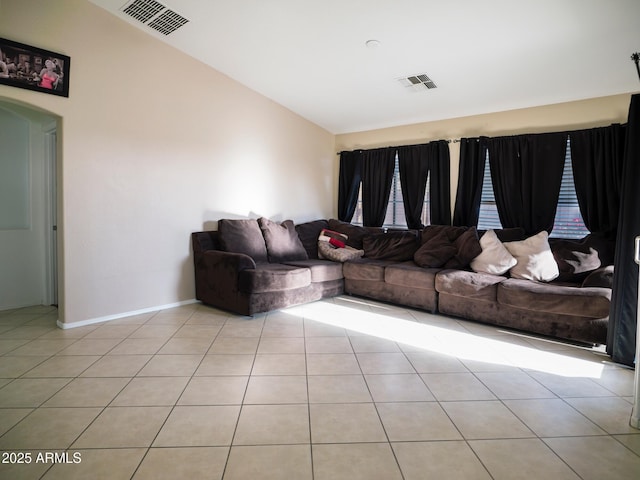 living room with vaulted ceiling, light tile patterned flooring, baseboards, and visible vents