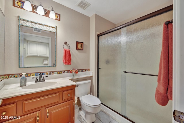 bathroom featuring walk in shower, tile patterned floors, toilet, and vanity