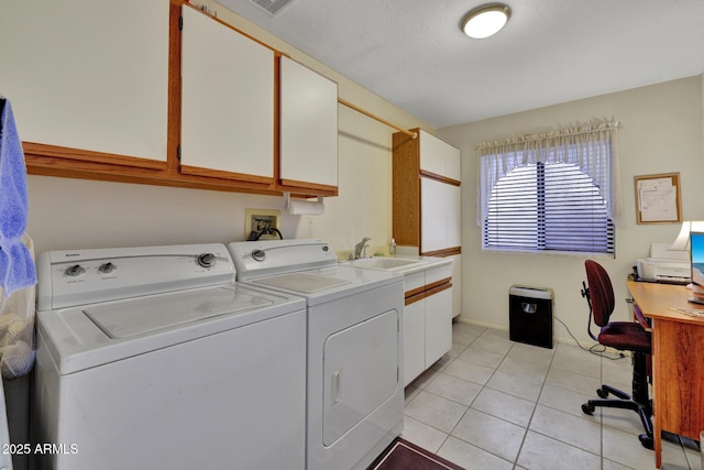 laundry area featuring light tile patterned flooring, cabinets, sink, and washing machine and dryer