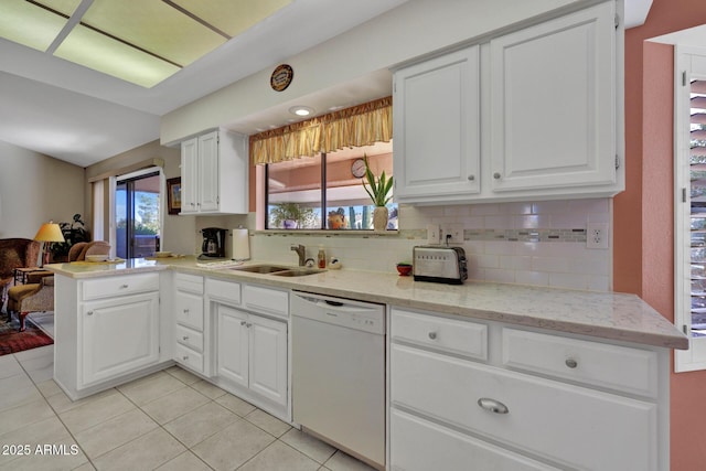 kitchen featuring sink, white cabinetry, white dishwasher, kitchen peninsula, and decorative backsplash