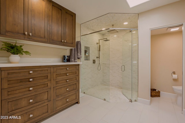 bathroom with toilet, a shower with shower door, vanity, and tile patterned floors