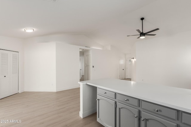 kitchen featuring ceiling fan, light hardwood / wood-style floors, gray cabinets, and vaulted ceiling