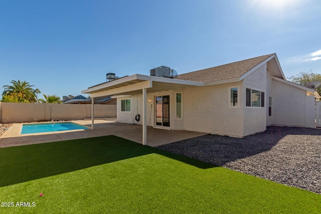 rear view of house featuring a fenced in pool, central air condition unit, a lawn, and a patio