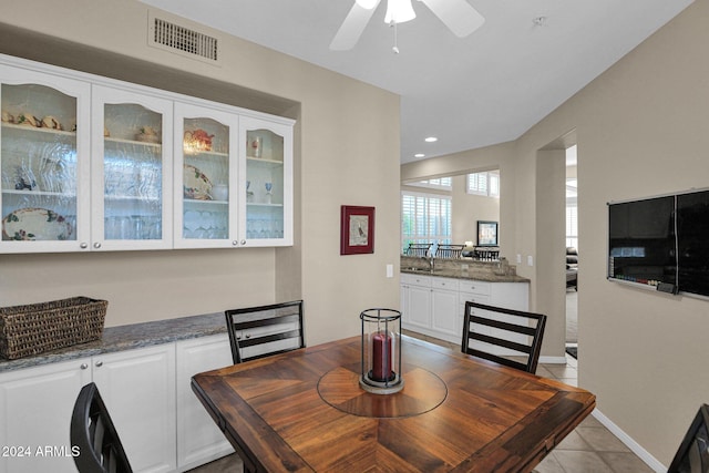 tiled dining space with ceiling fan