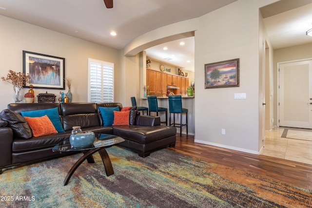 living room featuring ceiling fan and wood-type flooring