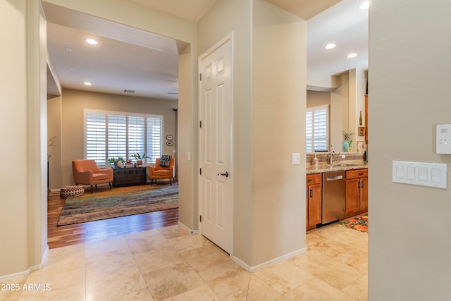 hall with light tile patterned floors and sink