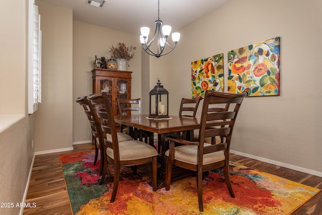 dining space with a notable chandelier and dark hardwood / wood-style flooring