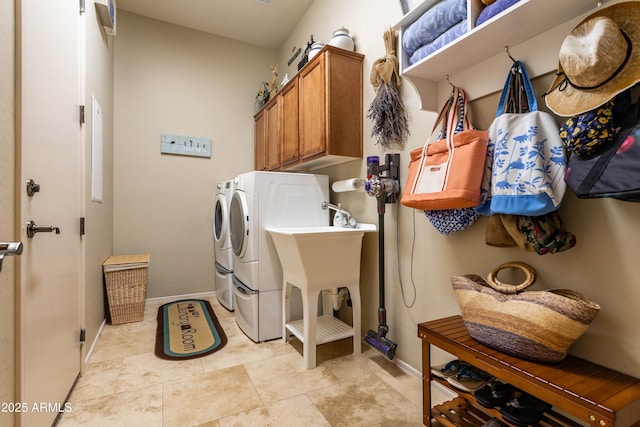 laundry room with separate washer and dryer, light tile patterned floors, and cabinets