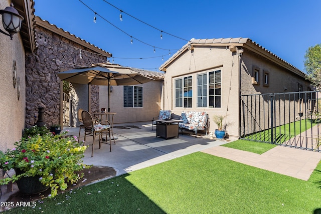 rear view of property with a yard, an outdoor living space, and a patio