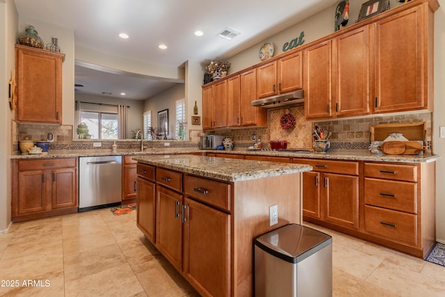 kitchen with a center island, light stone counters, kitchen peninsula, decorative backsplash, and appliances with stainless steel finishes