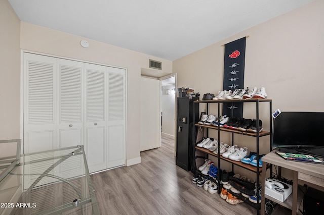 home office with baseboards, visible vents, and wood finished floors