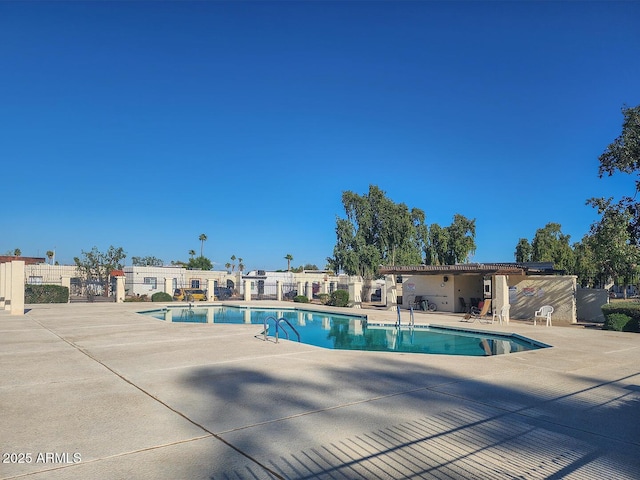 pool with a patio and fence