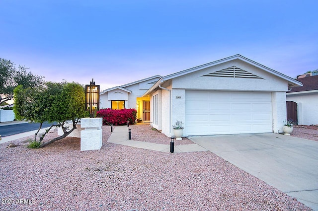 ranch-style house featuring driveway, stucco siding, and an attached garage