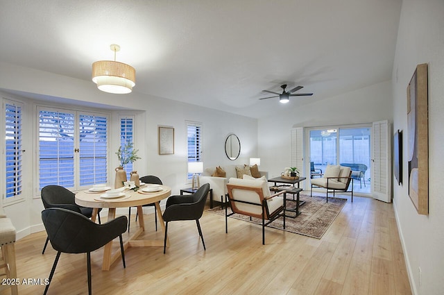 dining room featuring baseboards, a ceiling fan, and light wood finished floors
