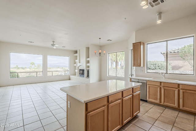 kitchen featuring visible vents, light countertops, light tile patterned floors, stainless steel dishwasher, and a sink