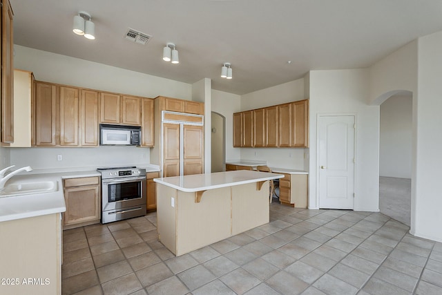 kitchen with a sink, visible vents, arched walkways, and stainless steel range with electric cooktop