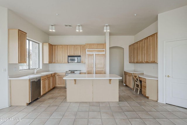 kitchen featuring visible vents, a kitchen island, light countertops, appliances with stainless steel finishes, and a sink