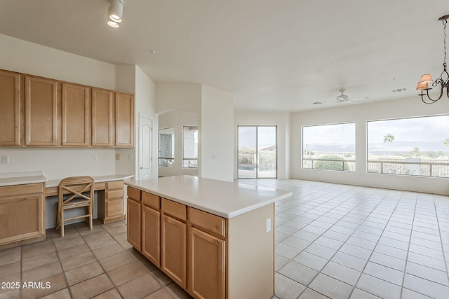 kitchen with light tile patterned floors, built in study area, open floor plan, and light countertops