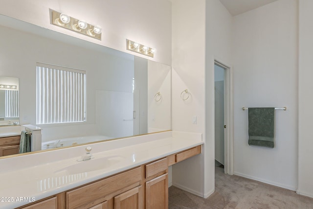 bathroom featuring baseboards, a high ceiling, a bath, and vanity