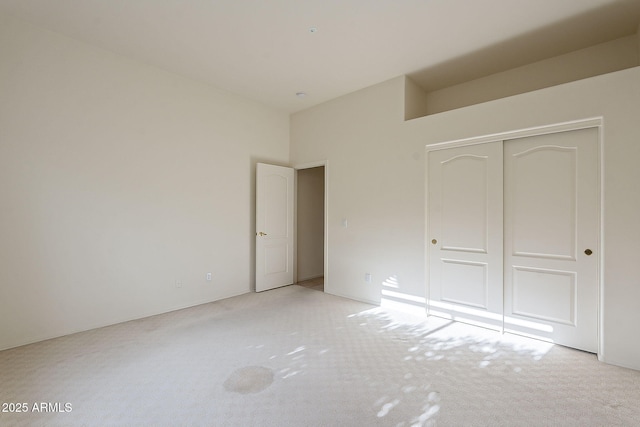 unfurnished bedroom with a closet and light carpet