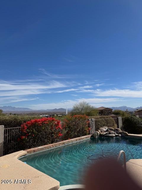 view of pool featuring a fenced in pool, a mountain view, and a fenced backyard