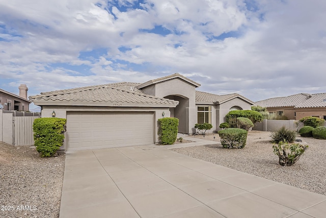 view of front of property featuring fence, concrete driveway, a tile roof, stucco siding, and a garage