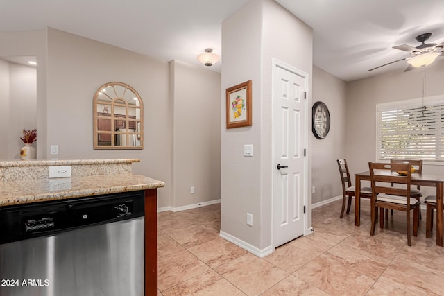 kitchen featuring light stone counters, stainless steel dishwasher, light tile patterned flooring, and ceiling fan