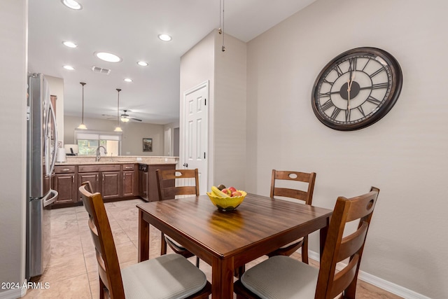 dining area with ceiling fan, light tile patterned floors, and sink